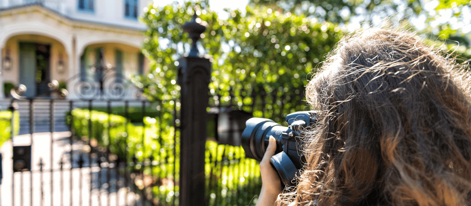 A professional photographer taking photos of the outside of a house.