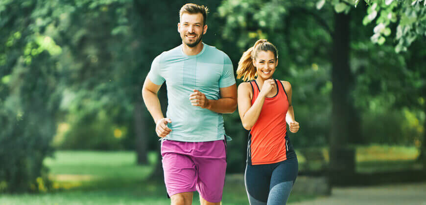 Image of couple in fitness gear exercising in the park together. 