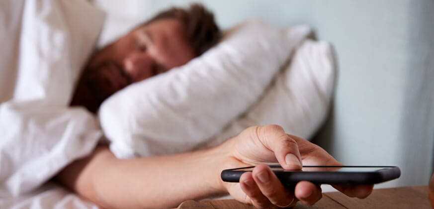 Image of man with head on bed pillow.