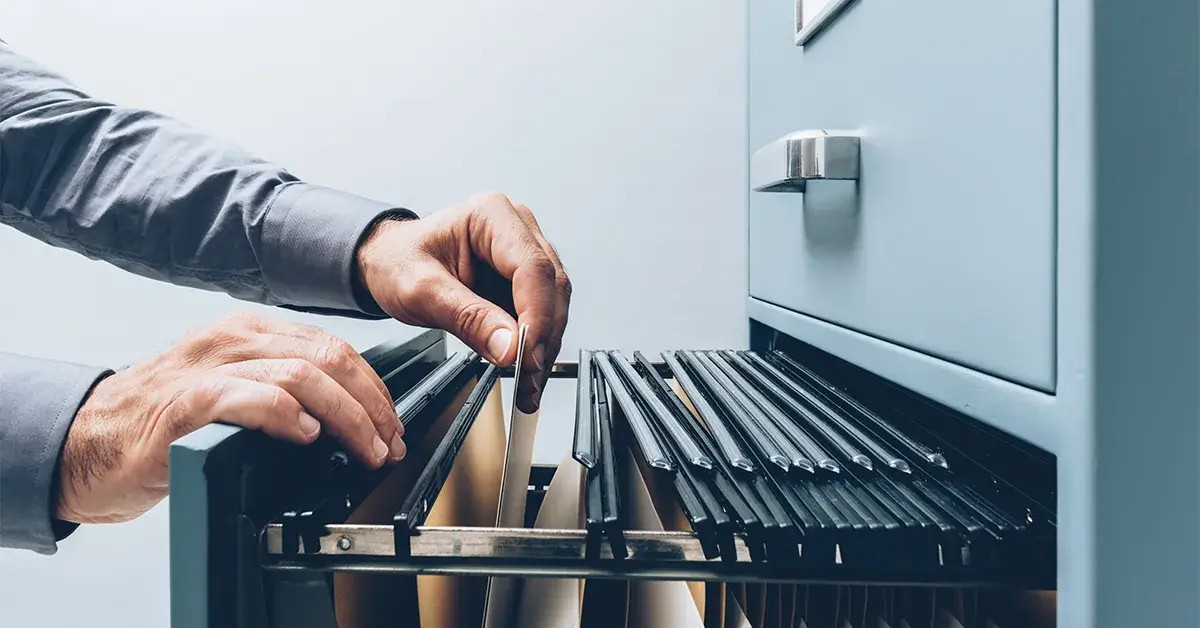 person looking through files in a filing cabinet