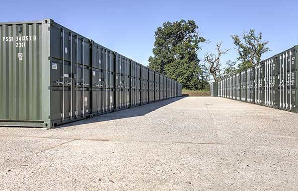 A row of green containers lined up outside ona. sunny day