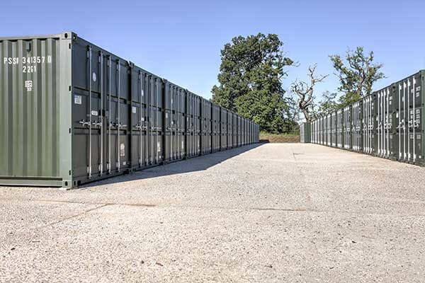 A row of green containers lined up outside ona. sunny day