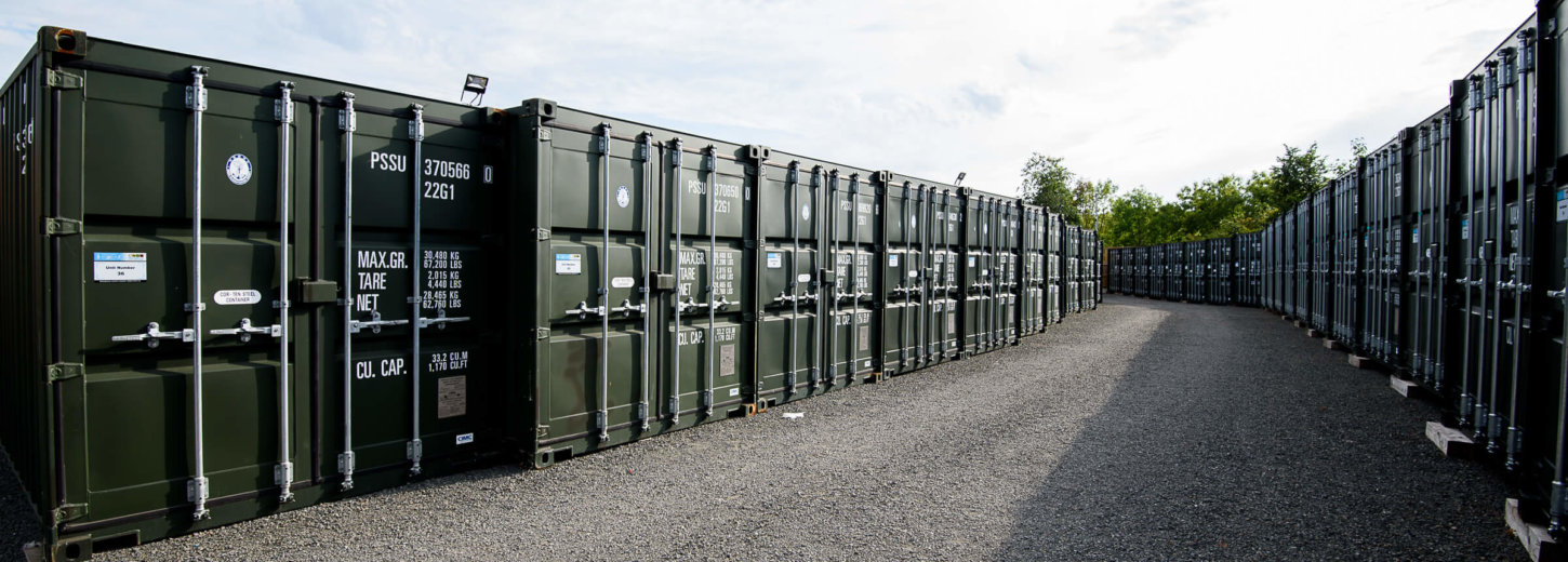 A row of green storage containers lined up outside