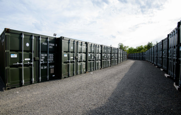 A row of green storage containers lined up outside