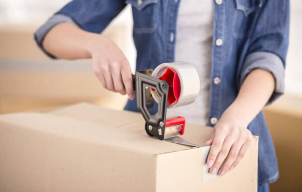Image of a man putting sellotape over a cardboard box.