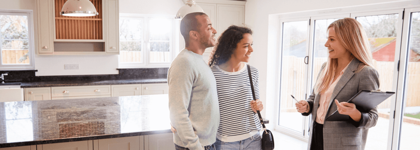 A couple looking around a house for sale with an estate agent.