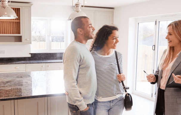 A couple looking around a house for sale with an estate agent.