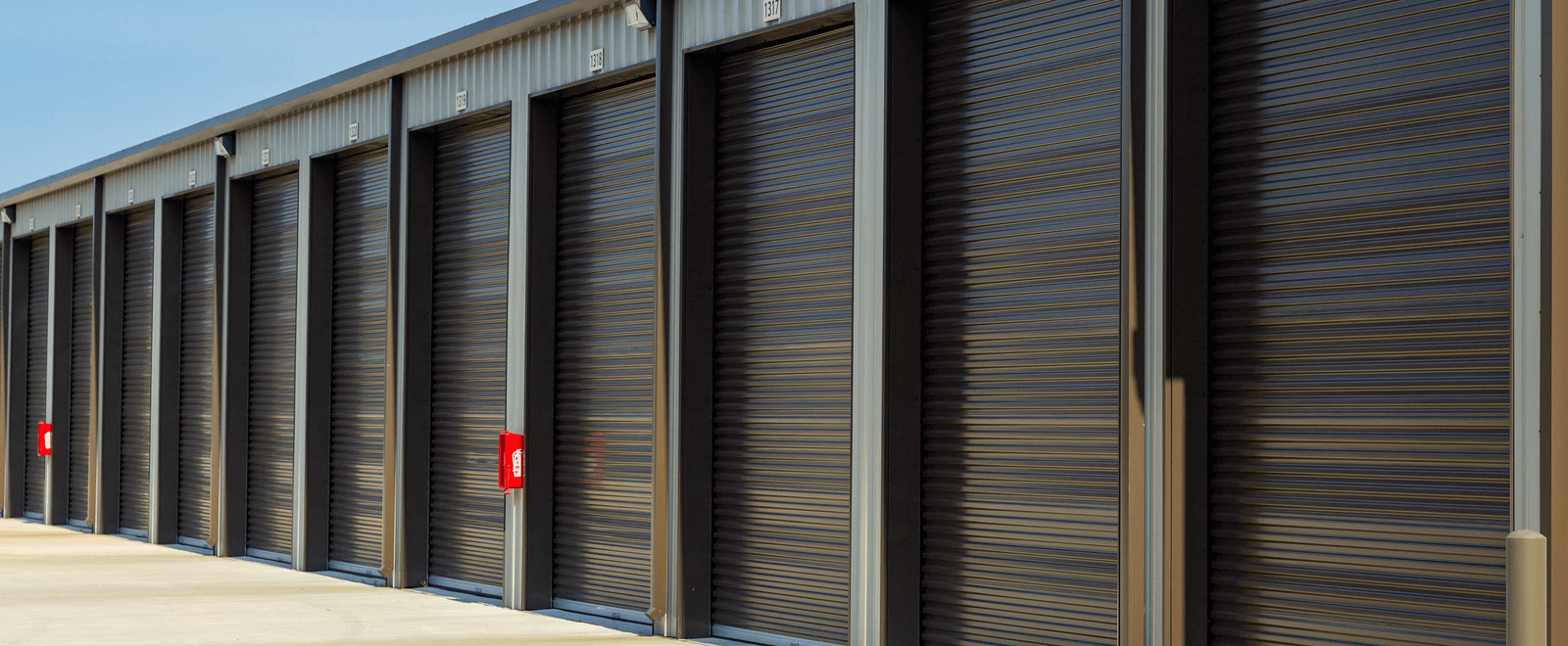 A row of outdoor black self storage units.