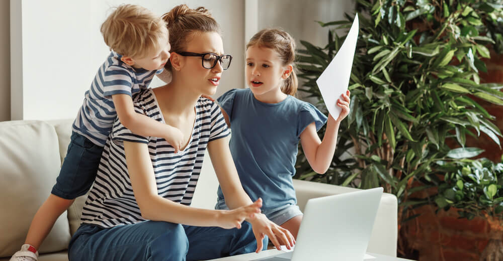 Image of a busy parent with two children asking questions and wanting attention.