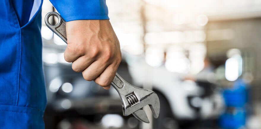 A car mechanic with a spanner in hand. 