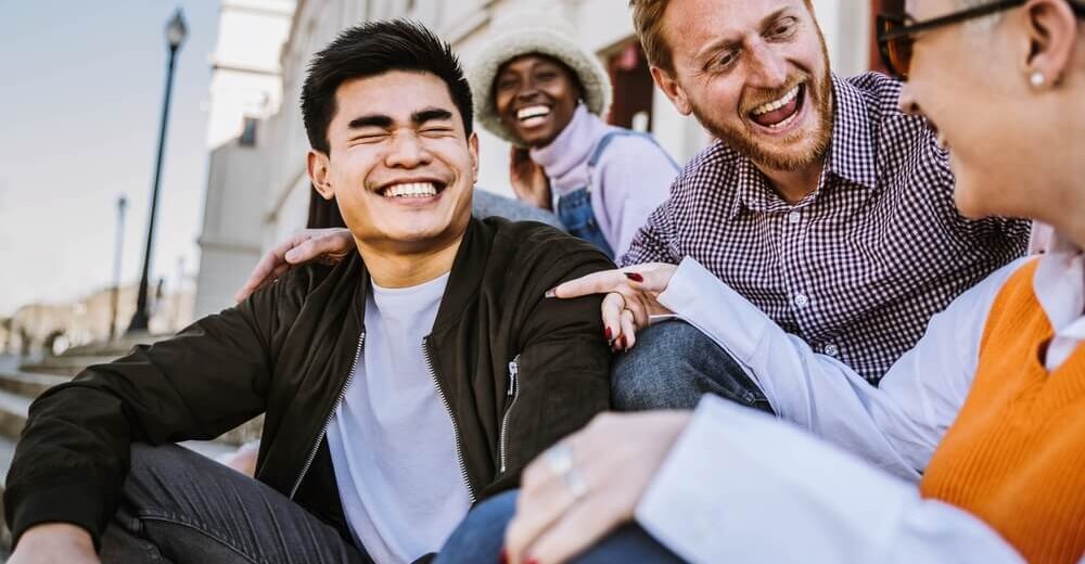 Image of students in conversation laughing together.