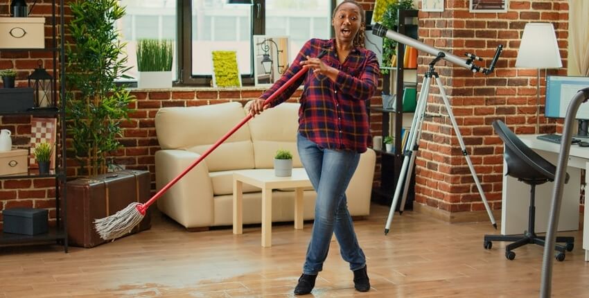 Image of a woman cleaning the floor at home.