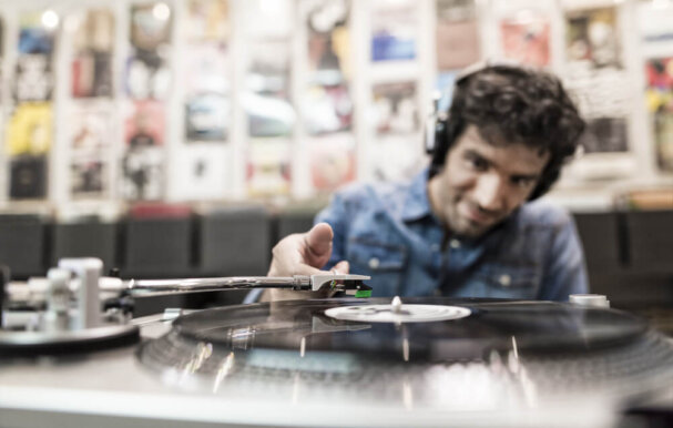 Image of a man playing a record on a turntable.