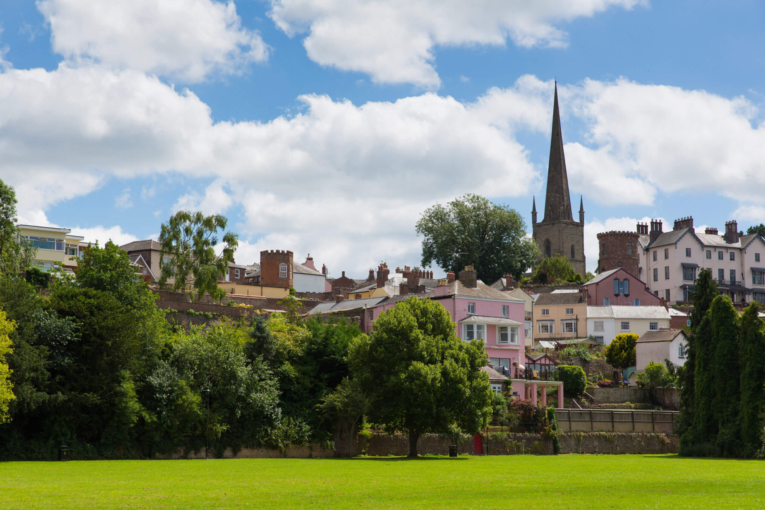 An image of ross on wye in the distance with trees and grass surrounding it.