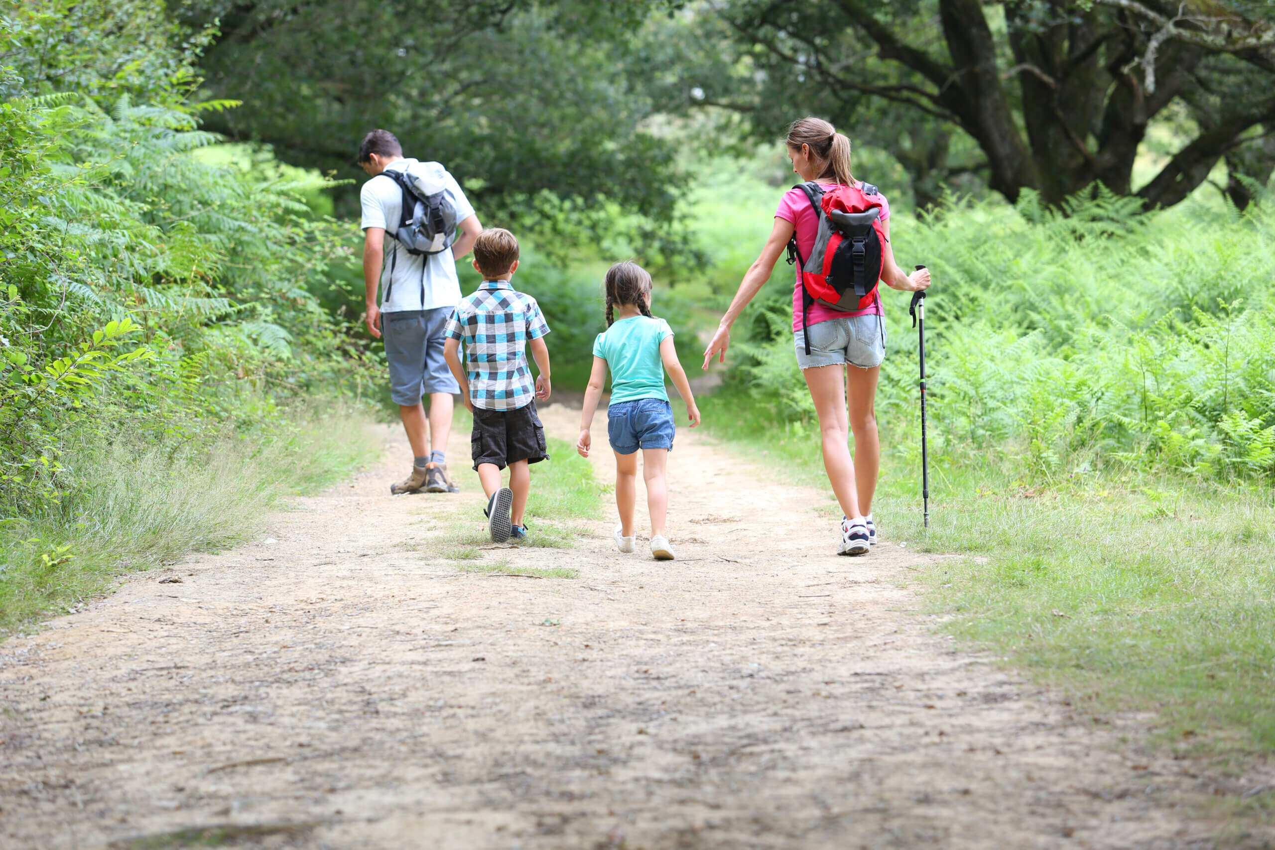 An image of a family of four walking down a path, exploring the outdoors on their day trip from Newbury.