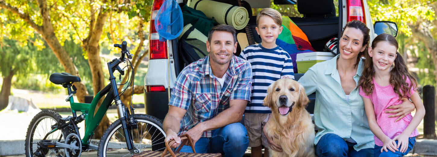 An image of a family of four with a golden retriever posing for a photo on their day trip from newbury.